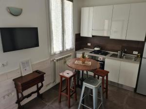 a kitchen with white cabinets and a small table and stool at FLORENCE QUARTERS in Florence