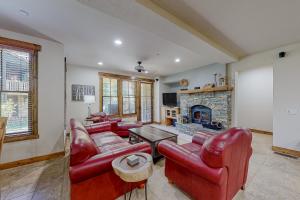 een woonkamer met rode lederen meubels en een open haard bij Lodges 1125 in Mammoth Lakes