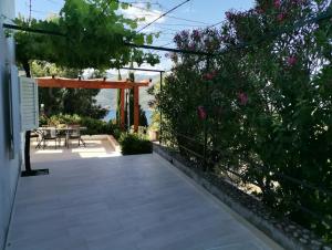 a patio with a table and chairs and flowers at Holiday Home Korkyra Sunrise in Korčula