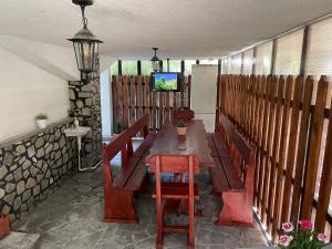 porche con mesa de madera, sillas y TV en Casa Shiro, en Sinaia