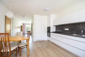uma cozinha com armários brancos e uma mesa de madeira em Sunny apartment em Olomouc