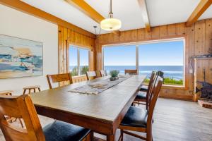 a dining room with a large wooden table and chairs at Sea Castle BeachFront Getaway in Lincoln Beach +28 photos