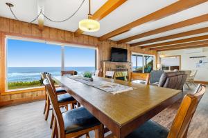a dining room with a table and chairs and a large window at Sea Castle BeachFront Getaway in Lincoln Beach