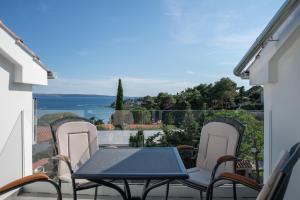 un tavolo e sedie su un balcone con vista sull'oceano di Apartmani Vrtodusic a Rab