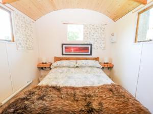 ein Schlafzimmer mit einem Bett in einem winzigen Haus in der Unterkunft Hugatree in Little Dunham