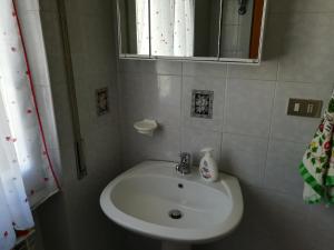 een badkamer met een witte wastafel en een spiegel bij Guado di Pio-appartamento panoramico in Castelpetroso