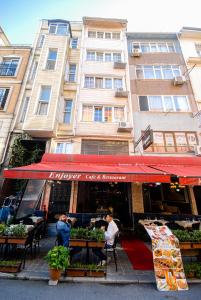 two people sitting at a table in front of a building at istanbul enjoyer suit in Istanbul