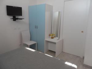 ein Badezimmer mit einem Spiegel und einem Waschtisch sowie einem TV in der Unterkunft Villa Al Mare Guest House in Tre Fontane