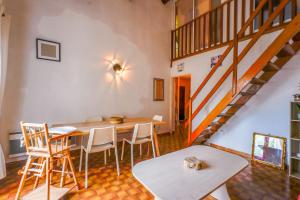 een kamer met een tafel en stoelen en een trap bij Appartement Cyria - Welkeys in Saint-Cyr-sur-Mer