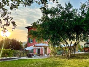 una casa roja con un árbol delante en Relais Valpolicella B&B, en Marano di Valpolicella
