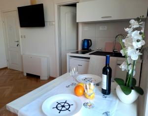 una mesa con dos copas y una botella de vino en Studio Apartments Regina en Bol