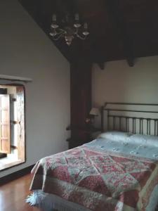 GuarazocaにあるCasa Rural Los Mozosのベッドルーム(キルト付きのベッド付)
