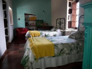 1 dormitorio con 2 camas con mantas amarillas en Casa Rural Los Mozos en Guarazoca