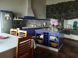 kuchnia z niebieskimi szafkami i stołem z krzesłami w obiekcie Casa Rural Los Mozos w mieście Guarazoca