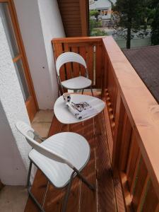 2 Stühle und ein Tisch auf dem Balkon in der Unterkunft Tamás Bátya Kunyhója in Balatonmáriafürdő