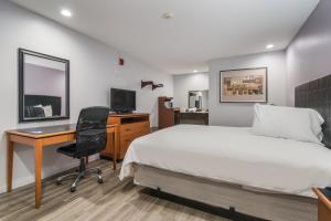 a bedroom with a bed and a desk and a computer at Knights Inn North Richland Hills in North Richland Hills +9 photos