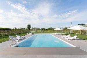 een zwembad met ligstoelen en parasols bij Country House Campofiore in Pontelongo