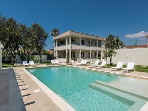 a house with a swimming pool in front of a house at Palazzo Michelangelo in Villasimius