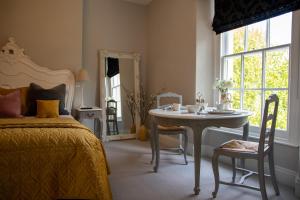 Schlafzimmer mit einem Bett, einem Tisch und einem Fenster in der Unterkunft Apple Tree Bed and Breakfast in Tavistock
