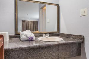 a bathroom counter with a sink and a mirror at Knights Inn North Richland Hills in North Richland Hills
