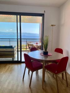 - un salon avec une table et des chaises offrant une vue dans l'établissement Grand T2 STANDING AJACCIO Proche centre et plages VUE PANORAMIQUE PARKING PRIVE, à Ajaccio