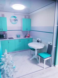 una cocina con armarios azules y una mesa y un árbol de Navidad en Tiffany apartment in the center, en Dnipro