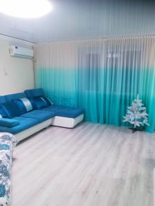 Tiffany apartment in the center في دنيبروبيتروفسك: غرفة معيشة مع أريكة زرقاء وشجرة عيد الميلاد