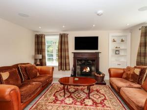 a living room with two couches and a fireplace at Hetland in Dumfries