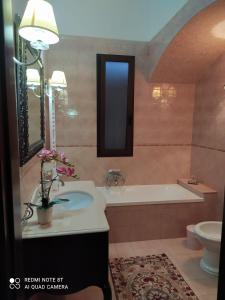 een badkamer met een bad, een wastafel en een toilet bij La casa nel borgo in Acaya