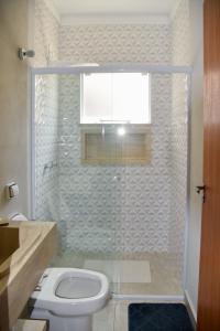 a bathroom with a shower with a toilet and a window at Casa com piscina e Wi-Fi em Itapetininga in Itapetininga