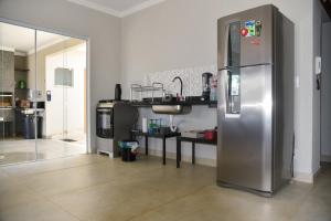 a kitchen with a large stainless steel refrigerator at Casa com piscina e Wi-Fi em Itapetininga in Itapetininga