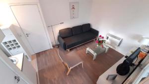 a living room with a black couch and a table at Mitten im Seenland und Spreewaldnah, schöner Garten in Storkow