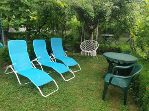 three chairs and a table and a table and a table and chairs at Guest House Dimitrije in Niška Banja