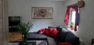 a living room with a gray couch with red pillows at Divine Lake House in Motnik