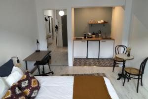 a room with a bed and a desk and a kitchen at Appartement Spacieux et Cosy - Strasbourg Centre in Strasbourg