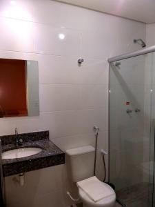 uma casa de banho com um WC, um lavatório e um chuveiro em Hotel Petaluma Piumhi em Piumhi
