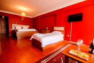 um quarto vermelho com 2 camas e uma televisão em istanbul enjoyer suit em Istambul