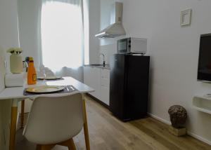 una cucina con tavolo e frigorifero nero di Suite 649 Bilocale con terrazzo a Modena