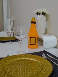 un tavolo con una bottiglia gialla e un bicchiere di Suite 649 Bilocale con terrazzo a Modena