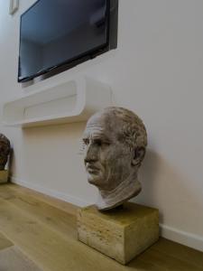 a bust of a man in front of a wall at Suite 649 Bilocale con terrazzo in Modena