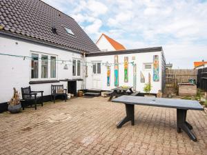 un patio con un banco frente a una casa en Holiday home Thyborøn IV, en Thyborøn