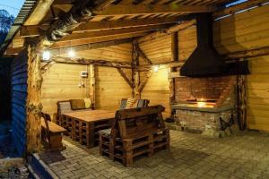 a wooden cabin with a table and a fireplace at Zbójowa Chata in Poronin