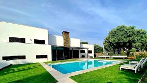 a house with a swimming pool in the yard at Villa La Roca Madrid in Guadarrama