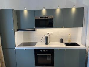 a kitchen with gray cabinets and a sink at Bella Mia - Chic apartment near Orly Rport 15mns frm Paris in Choisy-le-Roi
