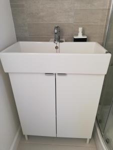 a white bathroom sink with a faucet at Maes Hyfryd in Gaerwen