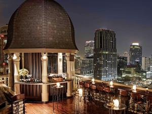 a restaurant with a view of a city skyline at Hotel Muse Bangkok Langsuan - MGallery - SHA EXTRA PLUS in Bangkok