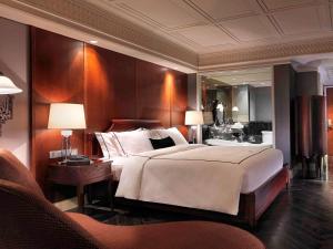 a hotel room with two beds and a television at Hotel Muse Bangkok Langsuan - MGallery - SHA EXTRA PLUS in Bangkok
