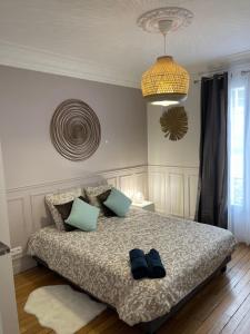 Un dormitorio con una cama con dos pares de zapatos. en Bella Mia - Chic apartment near Orly Rport 15mns frm Paris, en Choisy-le-Roi
