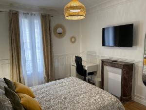 a bedroom with a bed and a desk and a television at Bella Mia - Chic apartment near Orly Rport 15mns frm Paris in Choisy-le-Roi