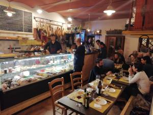 a group of people sitting at tables in a restaurant at La Casetta del Cantiniere in Castel di Lama